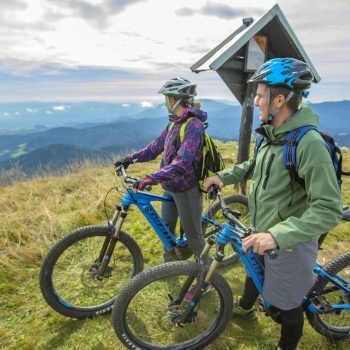 A beautiful shot of two cyclists standing and looking at the wonders of nature